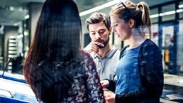 A group of printing plant engineers talking and working together at a large console