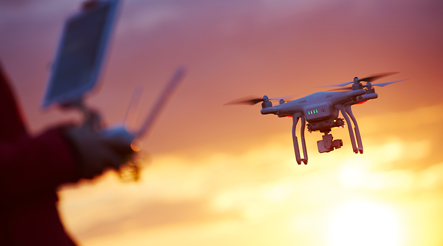 person flying drone at sunset