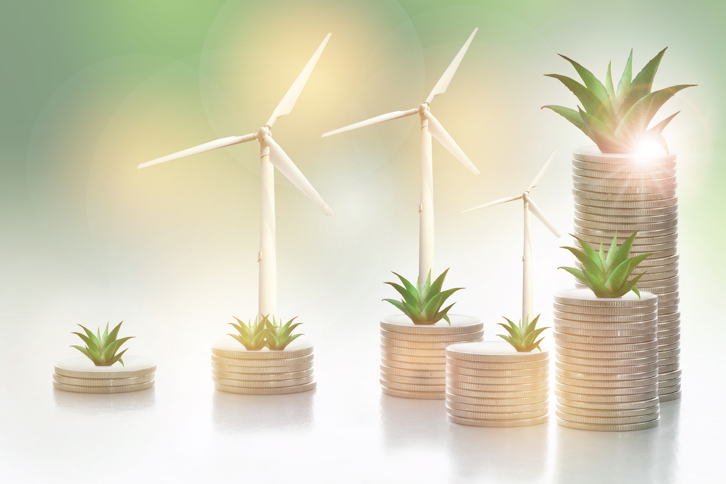 Growing money plant and turbine on stack of coins on abstract background